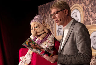Bauchredner Jörg Jará und Puppe Frau Sommer schauen in die Zeitschrift BRAVO