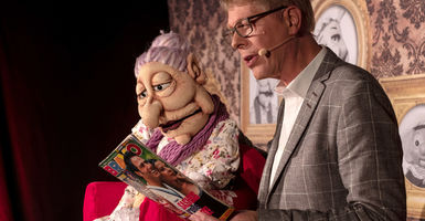 Bauchredner Jörg Jará und Puppe Frau Sommer schauen in die Zeitschrift BRAVO